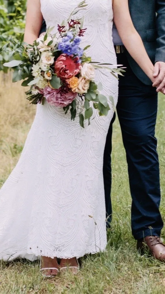 Bride holding a bouquet in a fitted lace wedding dress