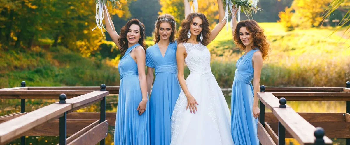 Bridesmaids in blue dresses with a bride in a white wedding gown