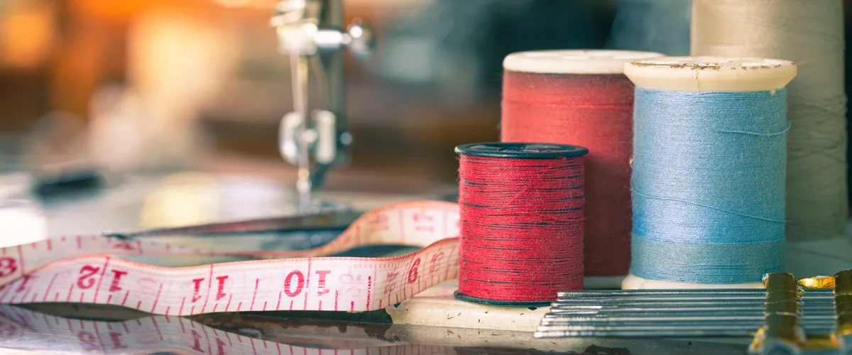 Spools of thread, tape measure and sewing machine for clothing alterations